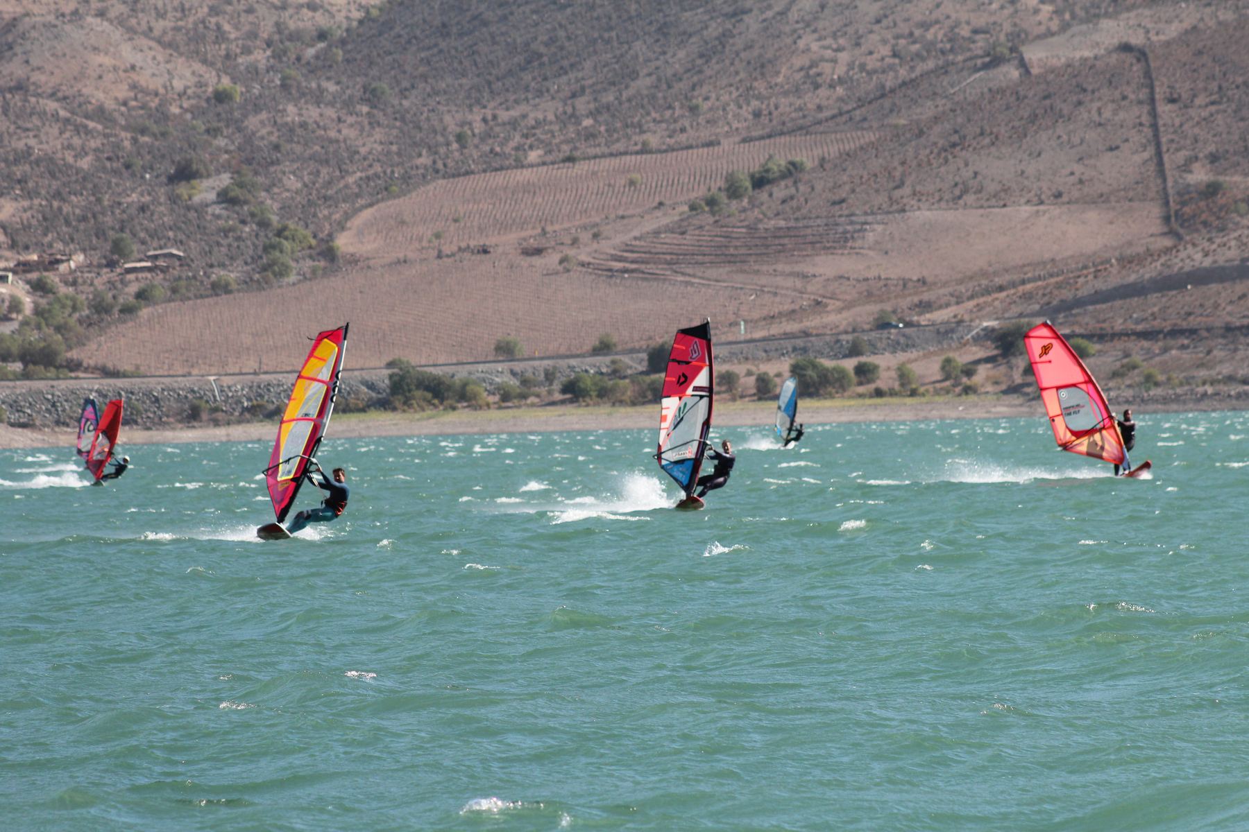 Windsurfistas navegando en el embalse