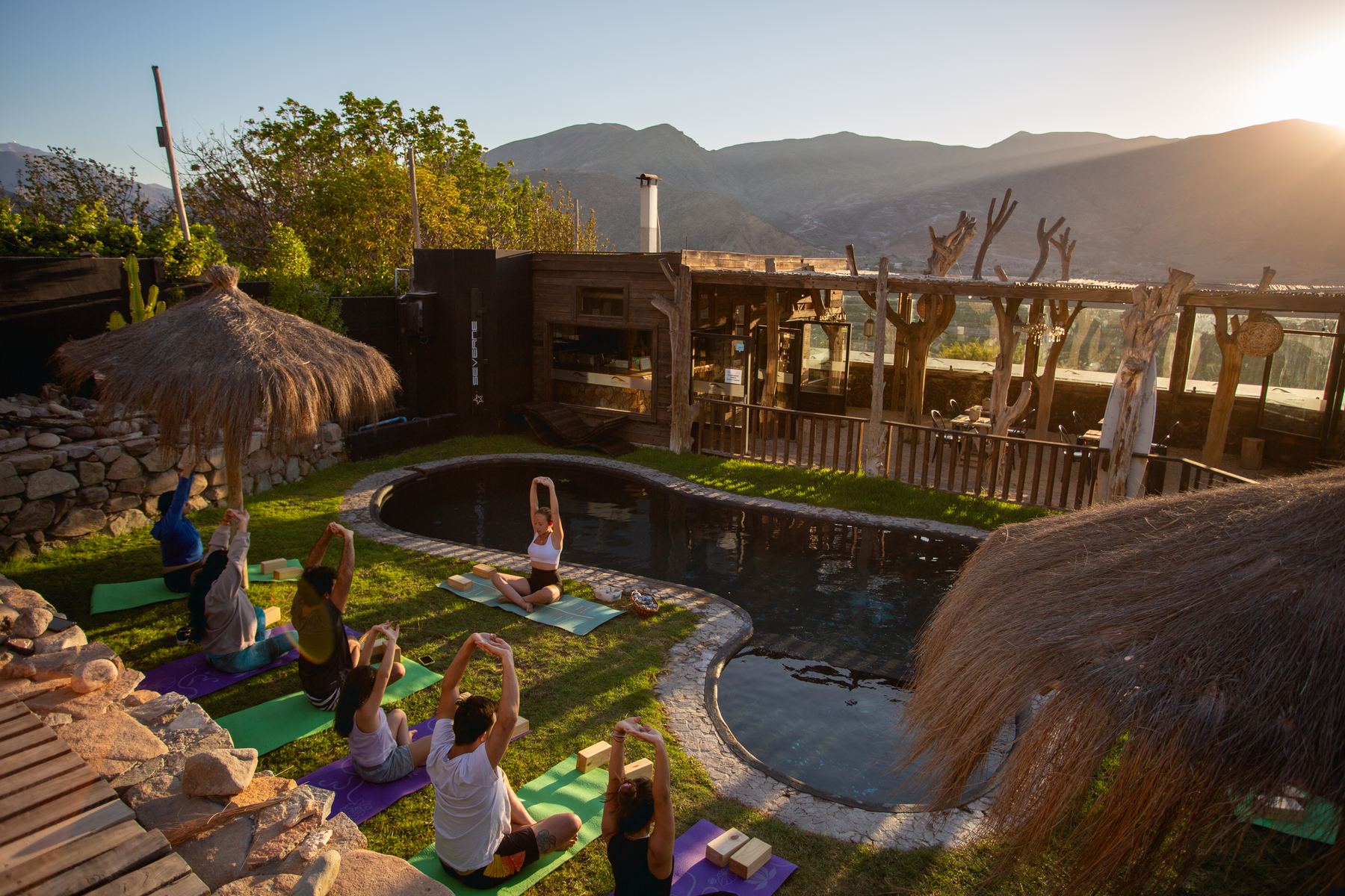 Clase de yoga junto a la piscina